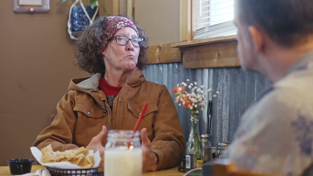Woman talking with man across diner table