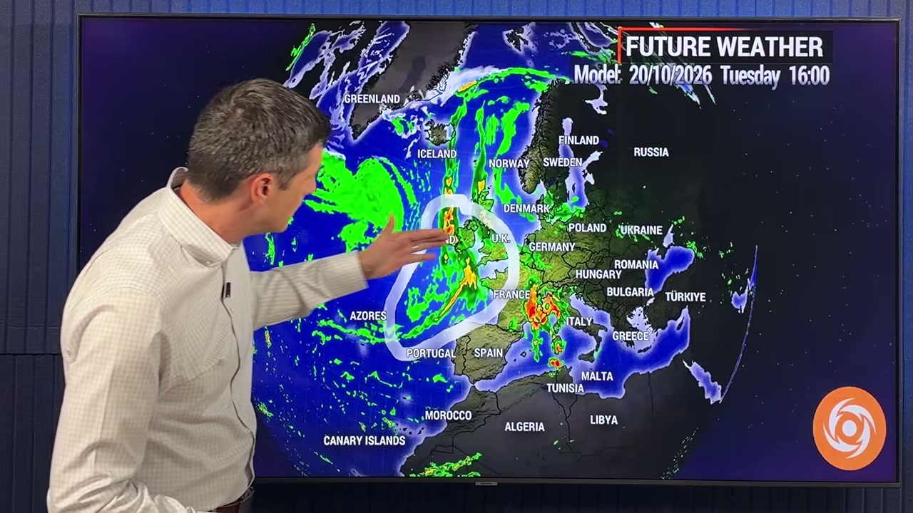 Weather presenter pointing at Europe rain forecast map
